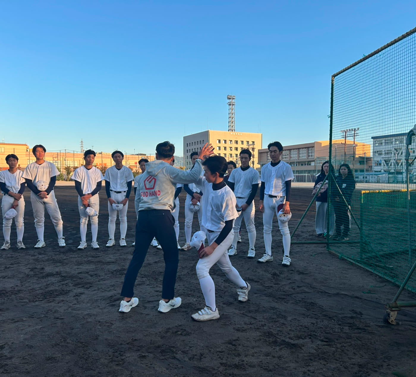 学生に野球の動きを指導している様子